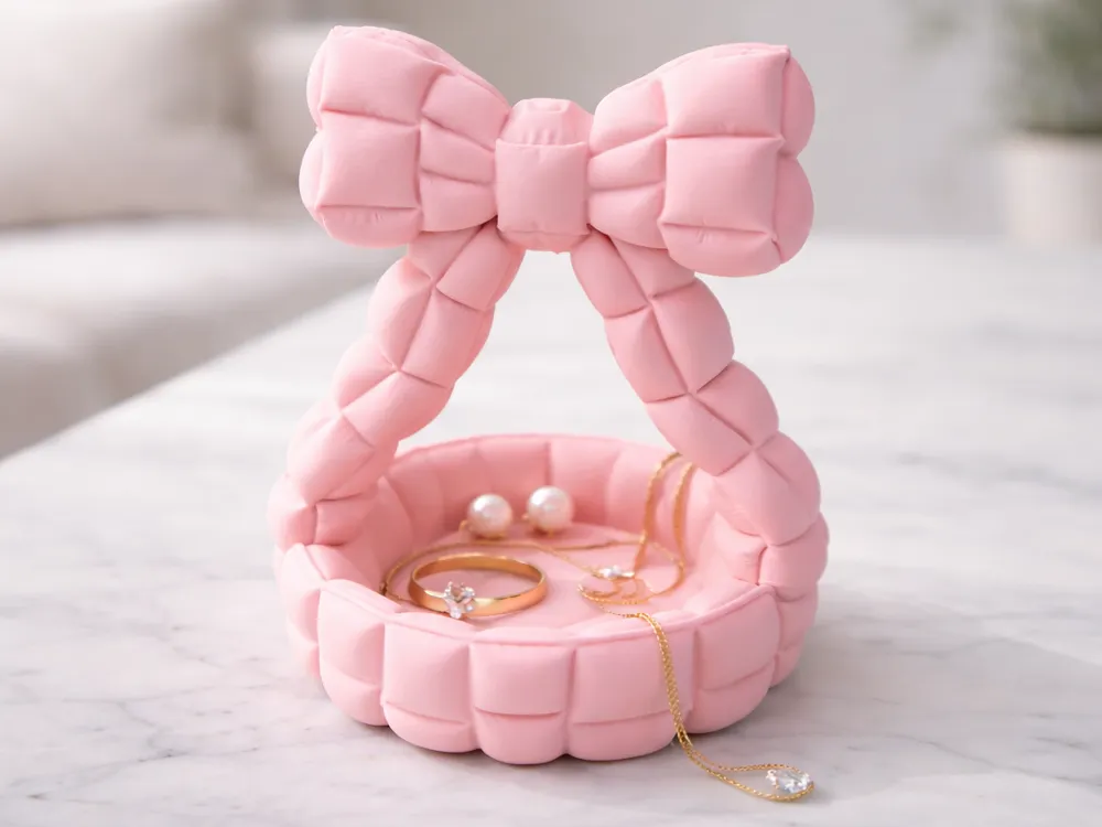 Quilted Bow Handle Catchall Basket — example colour. Includes: One finished item supplied; display accessories are excluded. Approximate dimensions (Width × Depth × Height): 1 supplied: 101.6 × 99.8 × 130.7 mm.