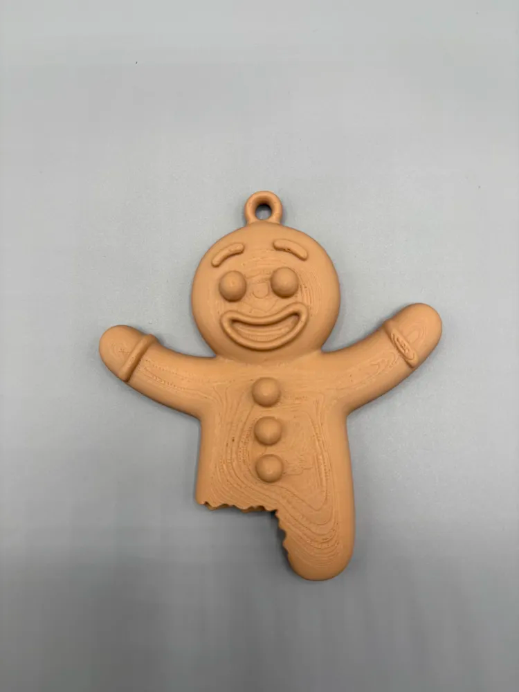 Bitten Gingerbread Man Christmas Ornament — example colour. Includes: One finished item supplied; display accessories are excluded. Approximate dimensions (Width × Depth × Height): 1 supplied: 101.6 × 89.6 × 15.2 mm.