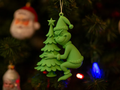 Grinch Hugging Tree Christmas Ornament — example colour. Includes: One finished item supplied; display accessories are excluded. Approximate dimensions (Width × Depth × Height): 1 supplied: 92.3 × 70.4 × 25.4 mm.