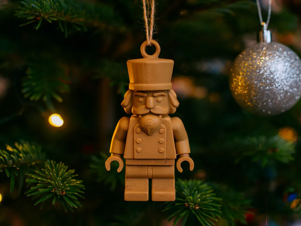 Brick-Style Nutcracker Hanging Ornament — example colour. Includes: One finished item supplied; display accessories are excluded. Approximate dimensions (Width × Depth × Height): 1 supplied: 101.6 × 58.4 × 18 mm.