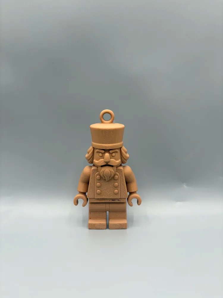 Brick-Style Nutcracker Hanging Ornament — example colour. Includes: One finished item supplied; display accessories are excluded. Approximate dimensions (Width × Depth × Height): 1 supplied: 101.6 × 58.4 × 18 mm.