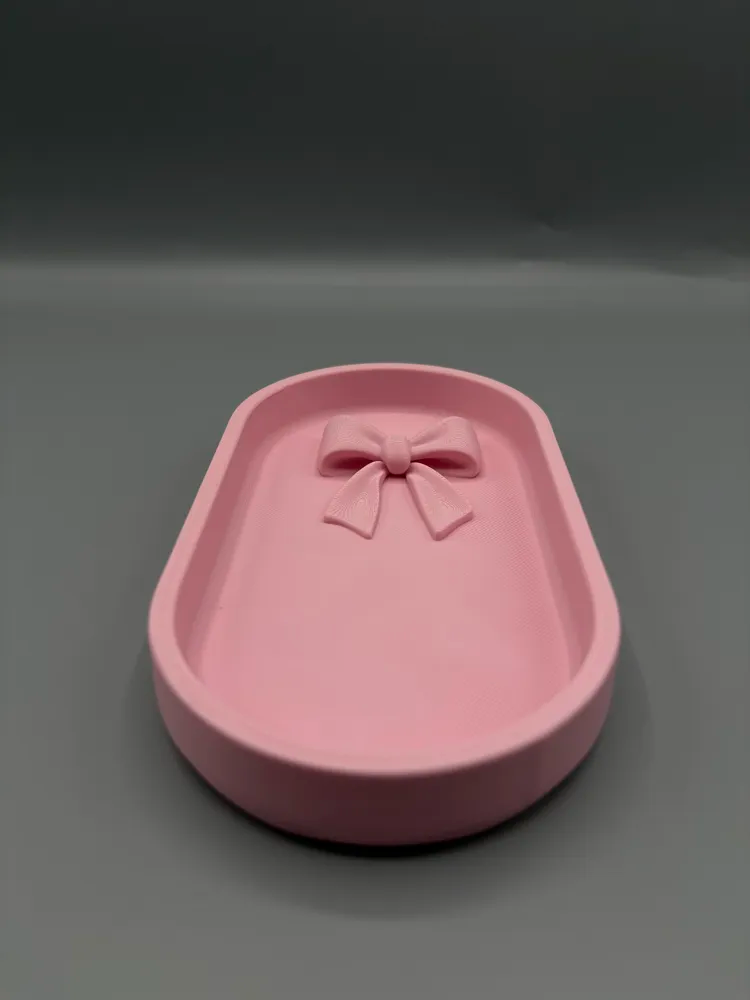 Sculpted Bow Oval Jewellery Tray — example colour. Includes: One finished item supplied; display accessories are excluded. Approximate dimensions (Width × Depth × Height): 1 supplied: 177.8 × 96.6 × 23.6 mm.