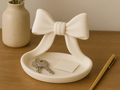 Sculptural Ribbon Bow Catchall Dish — example colour. Includes: One finished item supplied; display accessories are excluded. Approximate dimensions (Width × Depth × Height): 1 supplied: 124.1 × 118.3 × 101.6 mm.