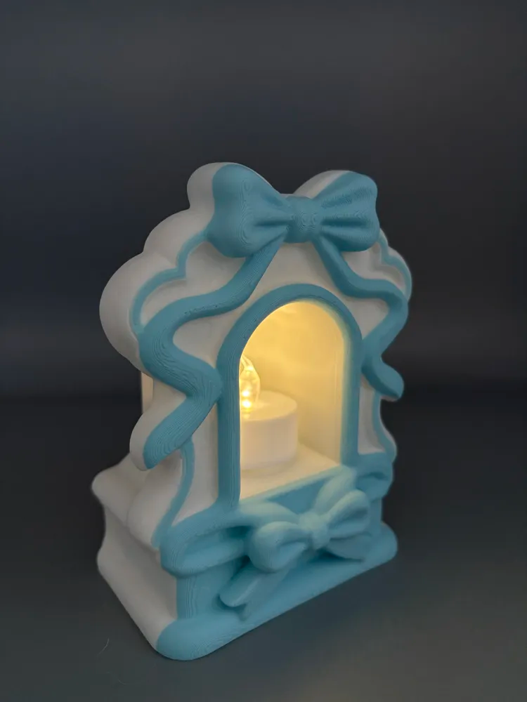 Ribbon Bow LED Tea Light Lantern — example colour. Includes: One finished item supplied; display accessories are excluded. Approximate dimensions (Width × Depth × Height): 1 supplied: 142.1 × 115.6 × 68.3 mm.