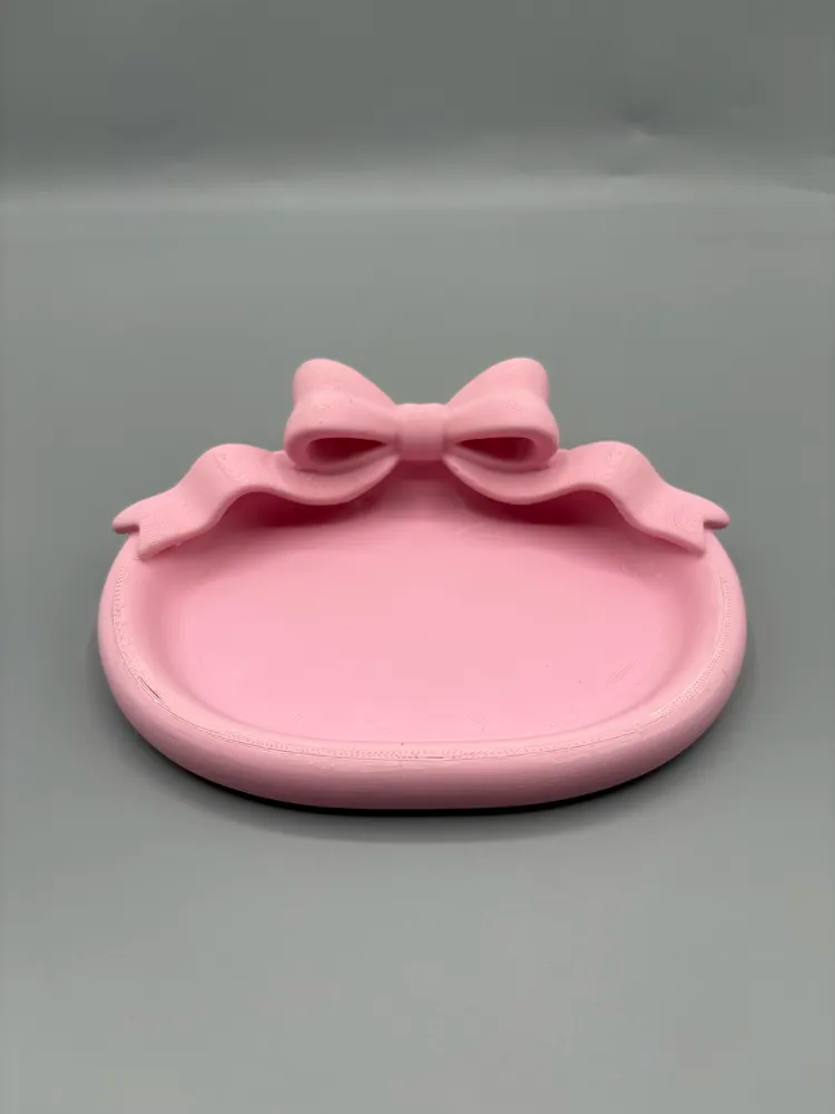 Bow Accent Oval Vanity Jewellery Tray — example colour. Includes: One finished item supplied; display accessories are excluded. Approximate dimensions (Width × Depth × Height): 1 supplied: 139.7 × 104.1 × 41.1 mm.