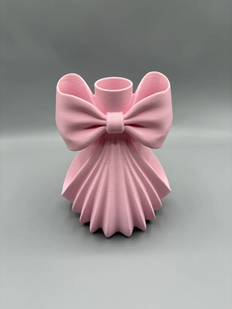 Pleated Bow Decorative Bud Vase — example colour. Includes: One finished item supplied; display accessories are excluded. Approximate dimensions (Width × Depth × Height): 1 supplied: 141.8 × 118.1 × 177.8 mm.