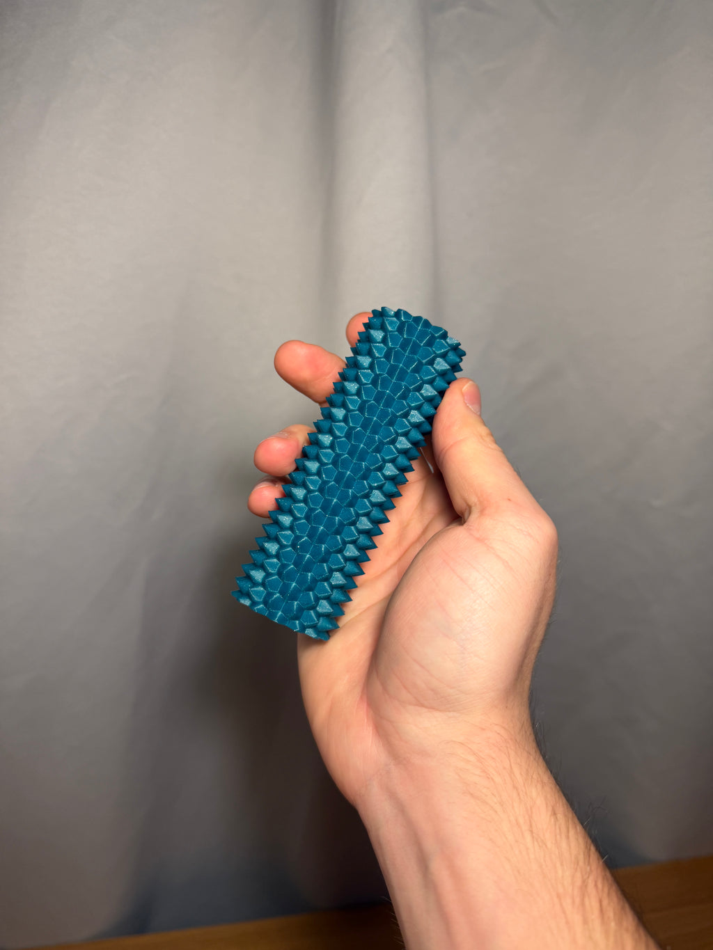 Spiky sensory fidget roller shown in a hand.