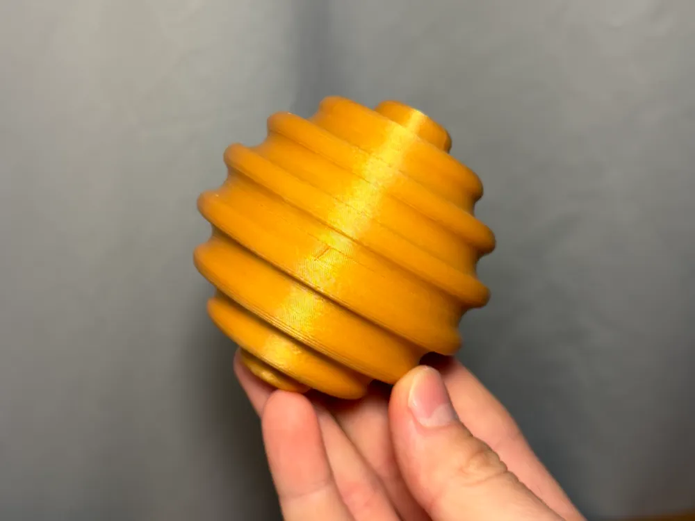 Sensory Fidget Sphere - Ribbed — example colour. Includes: one sensory fidget sphere - ribbed. Approximate dimensions (W × D × H): • Ribbed sphere halves (each): 80 × 79.8 × 40 mm. • Connector peg: 45.2 × 45.2 × 35.8 mm.