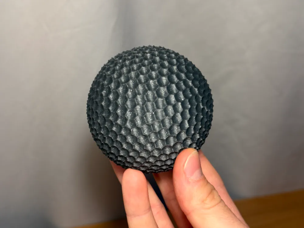 Sensory Fidget Sphere - Dimpled — example colour. Includes: one sensory fidget sphere - dimpled. Approximate dimensions (W × D × H): • Dimpled sphere half A: 81 × 80.8 × 40 mm. • Dimpled sphere half B: 81 × 80.8 × 40 mm. • Connector peg: 34.6 × 34.6 × 28.6 mm.