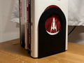 Minimalist Bookend Stand V2 — example colour. Includes: one minimalist bookend stand v2. Approximate dimensions (W × D × H): • Minimalist Bookend Stand V2: 110 × 110 × 155 mm.