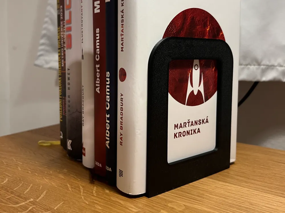 Minimalist Bookend Stand — example colour. Includes: one minimalist bookend stand. Approximate dimensions (W × D × H): • Minimalist Bookend Stand: 110 × 90 × 135 mm.