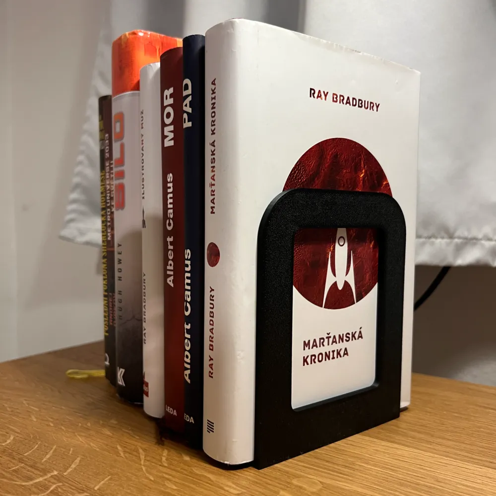 Minimalist Bookend Stand — example colour. Includes: one minimalist bookend stand. Approximate dimensions (W × D × H): • Minimalist Bookend Stand: 110 × 90 × 135 mm.