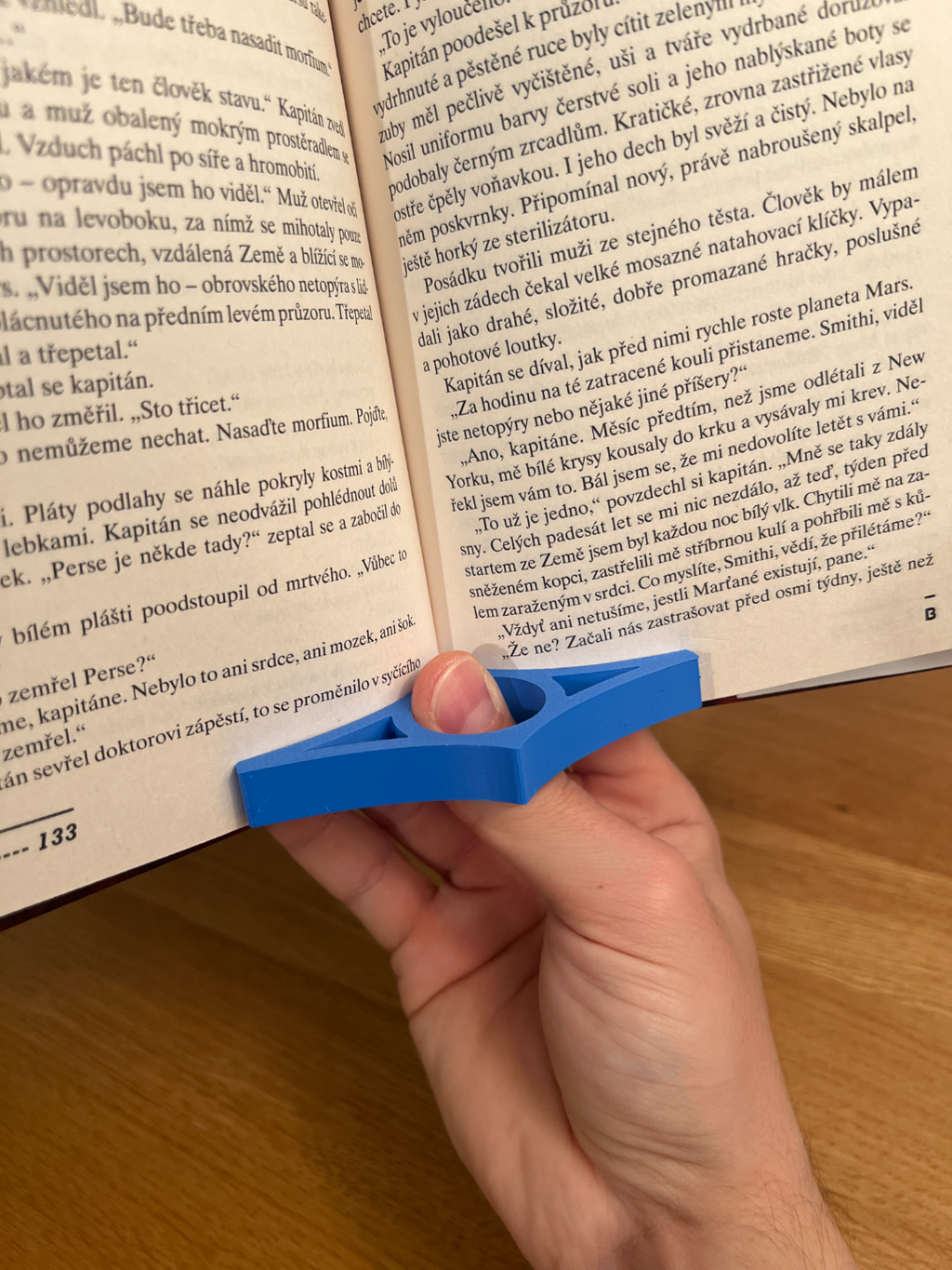 Side view of a blue 3D-printed book page holder