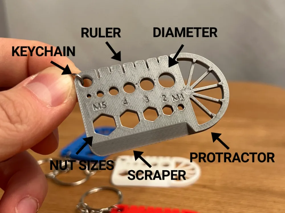 Ruler & Scraper Multi-Tool Keyring — example colour. Includes: one ruler & scraper multi-tool keyring. Approximate dimensions (W × D × H): • Ruler & Scraper Multi-Tool Keyring: 60 × 35 × 3 mm.