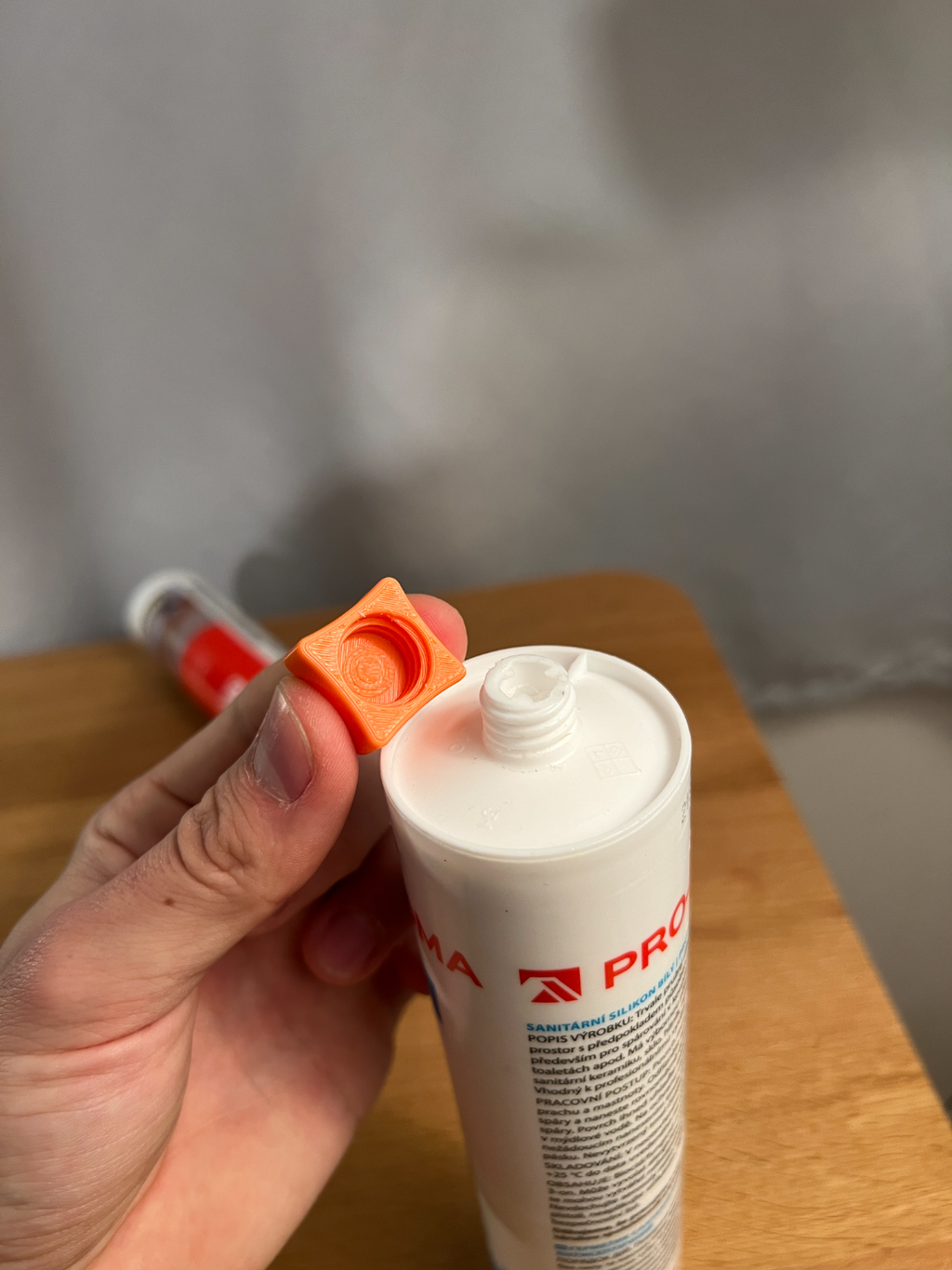 Orange printed cap shown beside an example silicone cartridge
